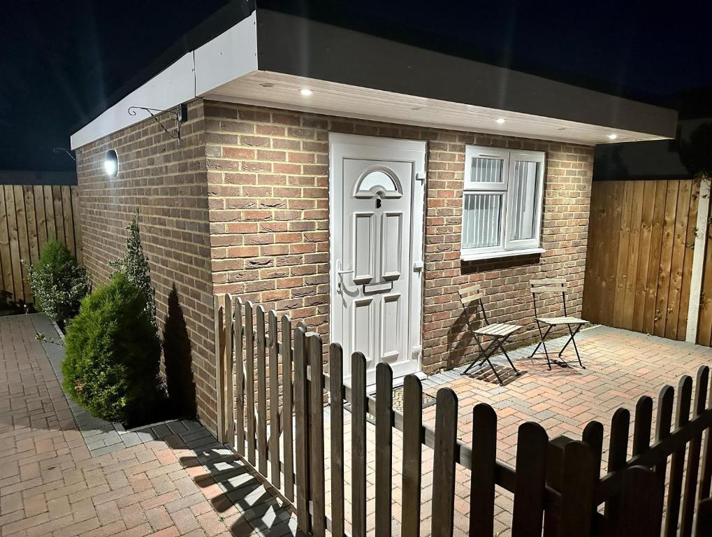 a brick house with a white door and a fence at Beautiful 1-Bed Modern Luxury Apartment in Luton in Luton