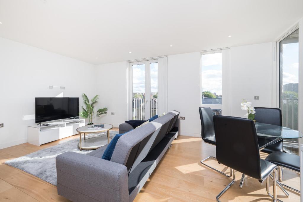 a living room with a couch and chairs and a tv at Chic London 1 bedroom flat in London