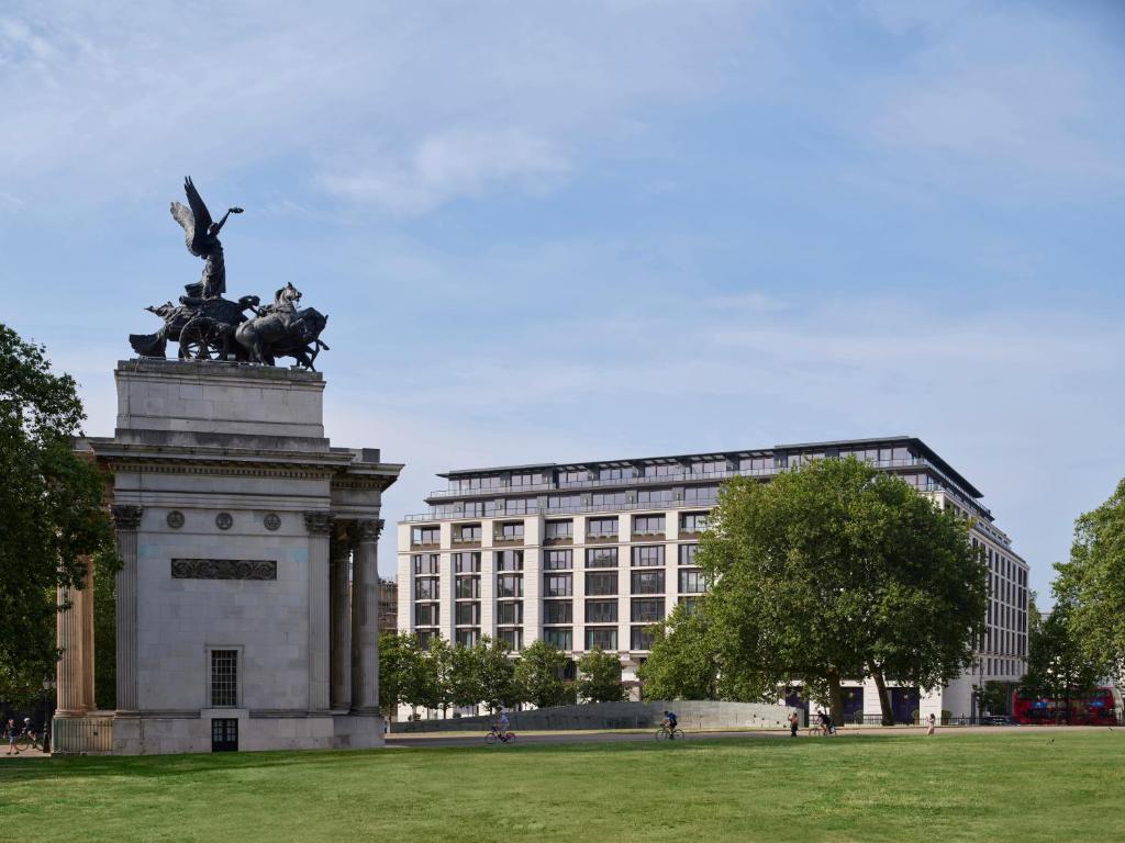 uma estátua num campo em frente a um edifício em The Peninsula London em Londres