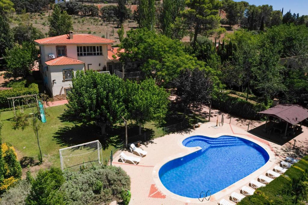 vista sul tetto di una piscina di fronte a una casa di Casa Rural Las Melias a Ciudad Real