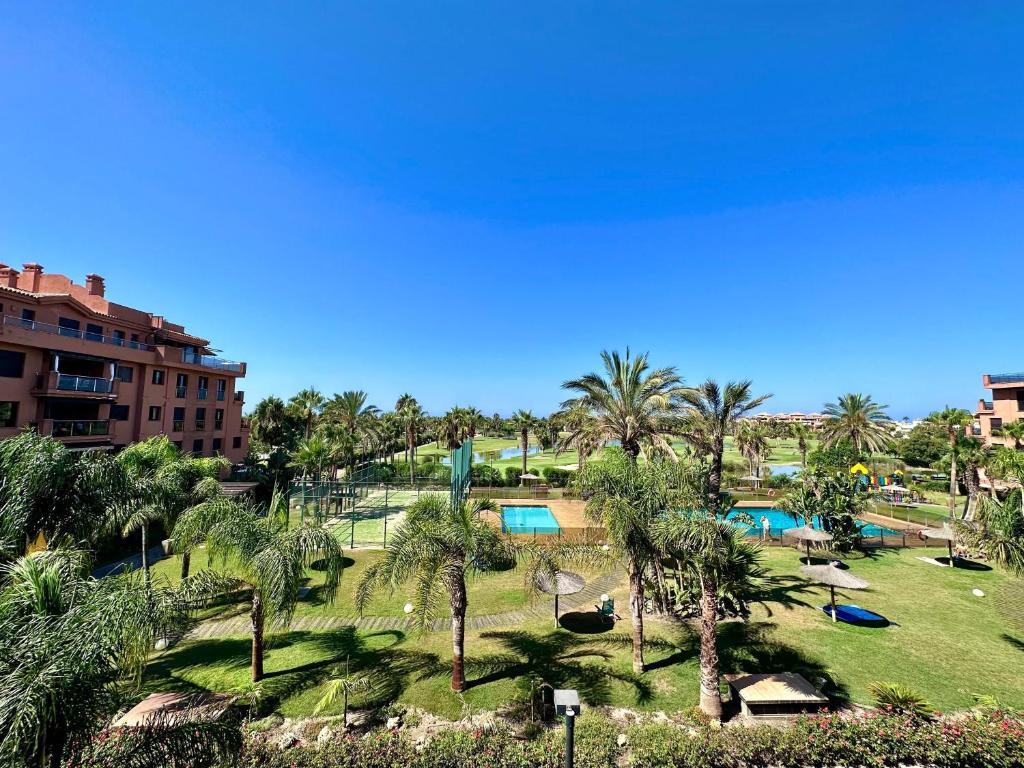 un resort con un parco di palme e una piscina di Dos Mares Apartamentos Playa Granada a Motril