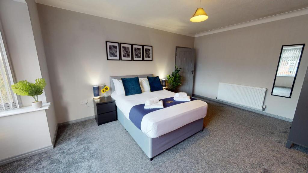 een slaapkamer met een groot bed met blauwe kussens bij South Drive Bungalow in Middlesbrough