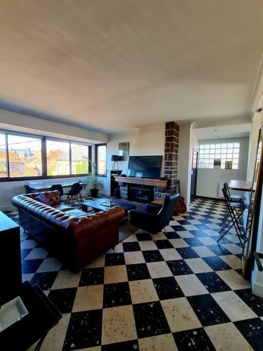 a living room with a couch and a checkered floor at Appartement 2 chambres in Aire-sur-la-Lys