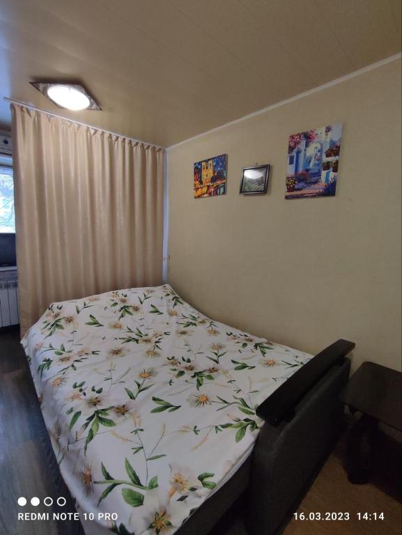 um quarto com uma cama com flores em Уютная 1я смарт-квартира ,м.Дворец спорта. em Kharkov