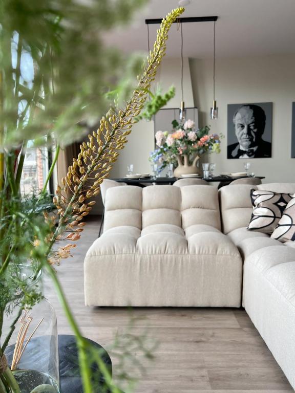 een woonkamer met een witte bank en een tafel bij Reen Luxury Stays - Waterpoort -2 bedrooms, 4 pers in Sneek