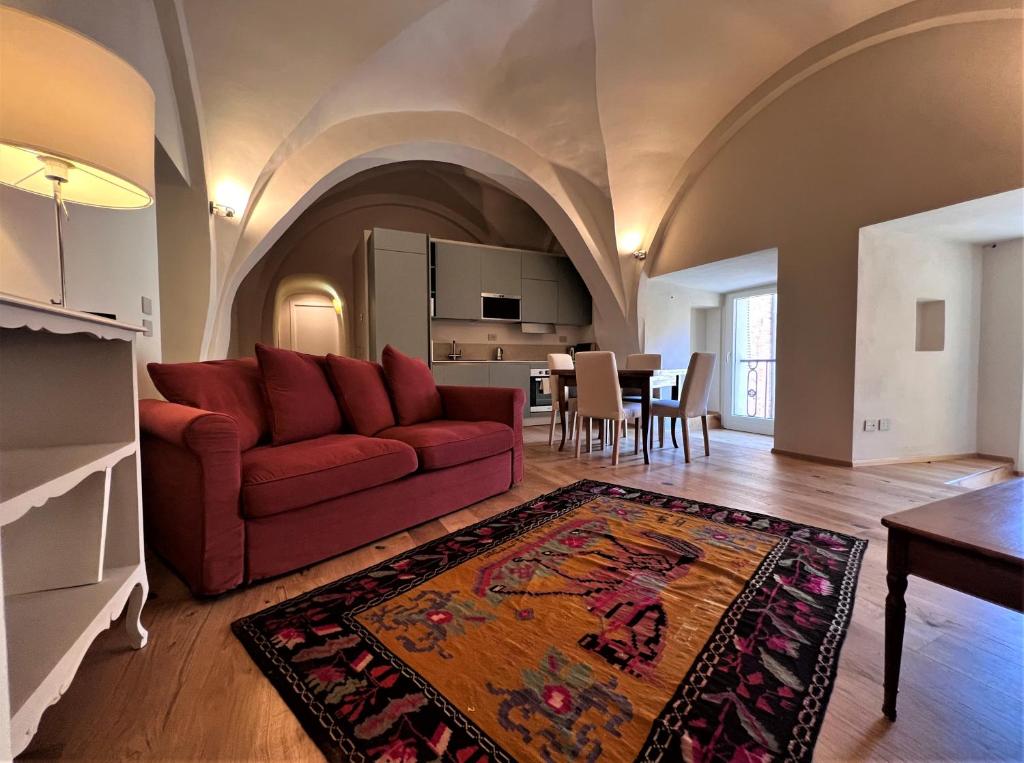 sala de estar con sofá rojo y cocina en Torre del Cavaliere, en Siena