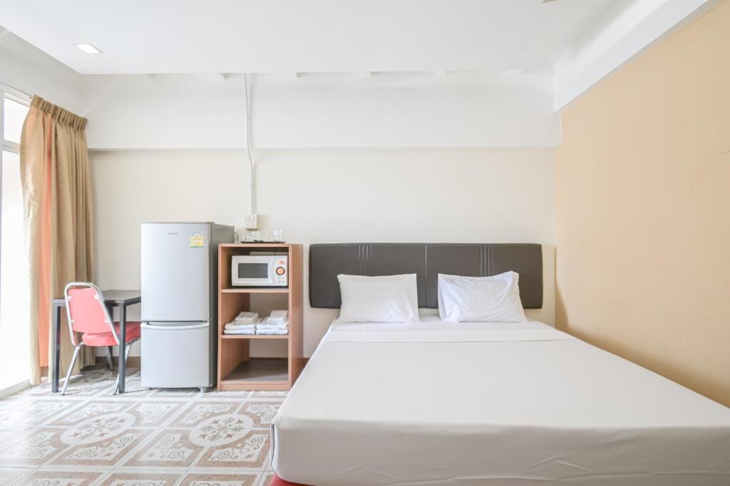 1 dormitorio con 1 cama, mesa y nevera en AC Habitat Bangkok, en Bangkok