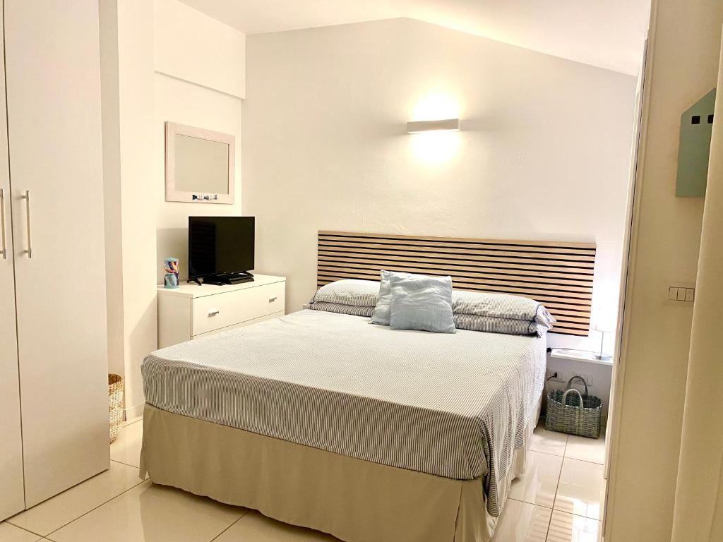 ein kleines Schlafzimmer mit einem Bett und einem TV in der Unterkunft La Casa Bianca in Ceriale