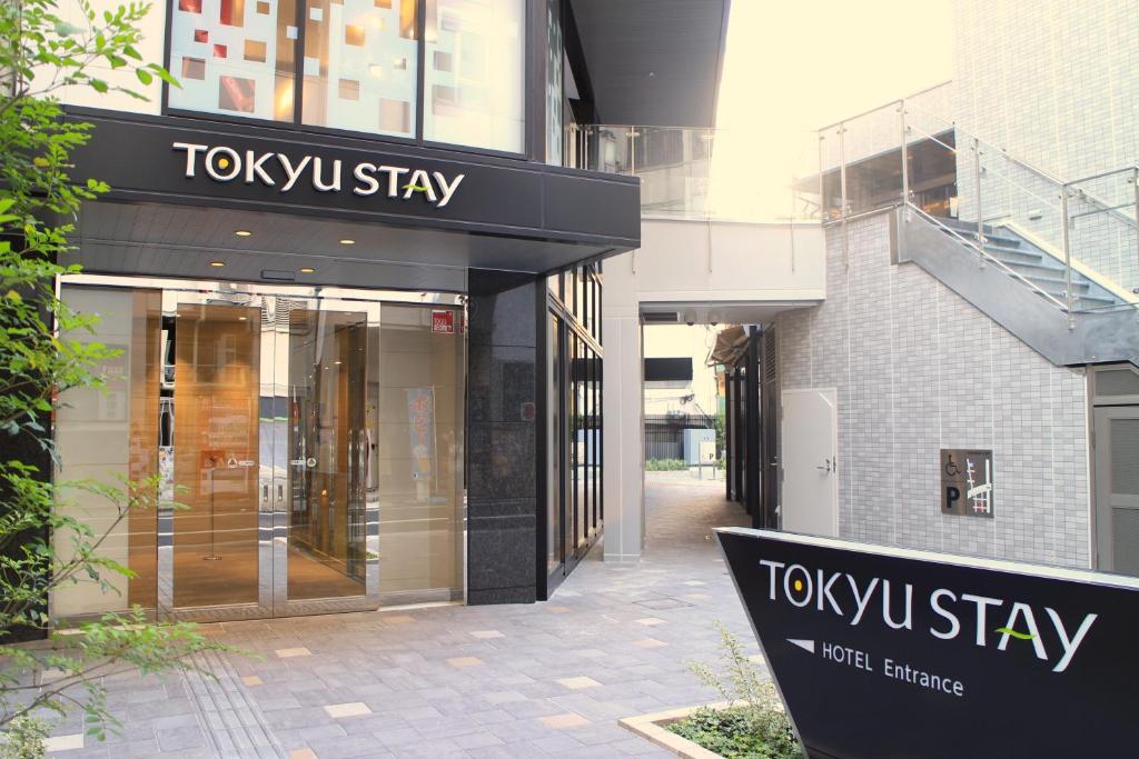 un cartello di soggiorno tokyu di fronte a un edificio di Tokyu Stay Shinjuku a Tokyo