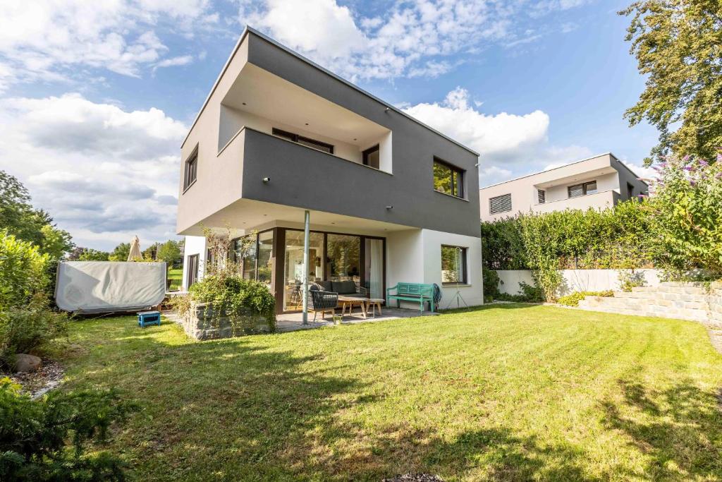 Blick auf ein Haus mit Garten in der Unterkunft Bauhausvilla am Ammersee in Herrsching am Ammersee