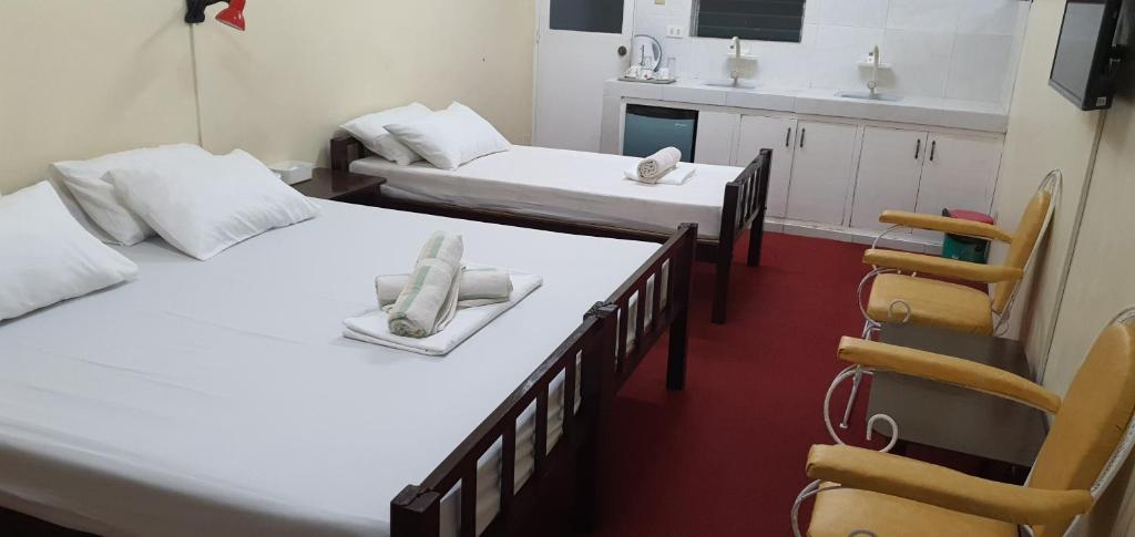 a room with two beds and a chair in it at Cool Martin Family Hotel and Resort in Bacoor