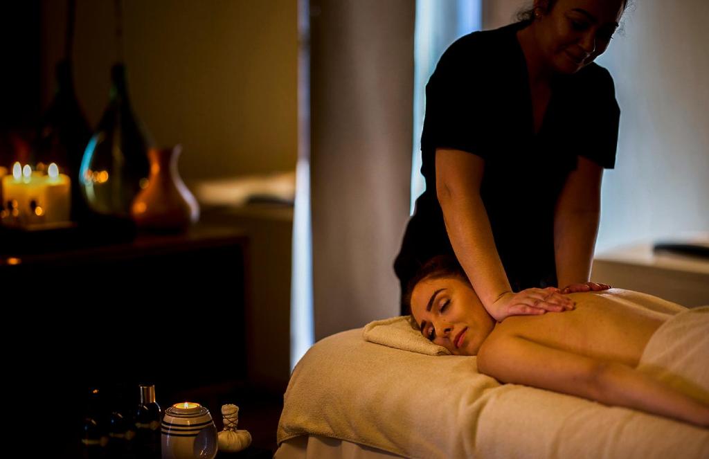 a woman standing on top of a woman laying on a bed at Octant Ponta Delgada in Ponta Delgada