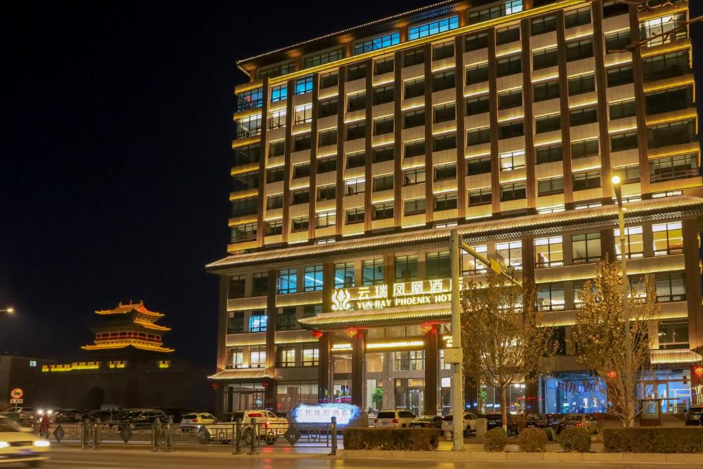 un grand bâtiment avec une façade éclairée la nuit dans l'établissement 云瑞凤凰酒店, à Jinzhong