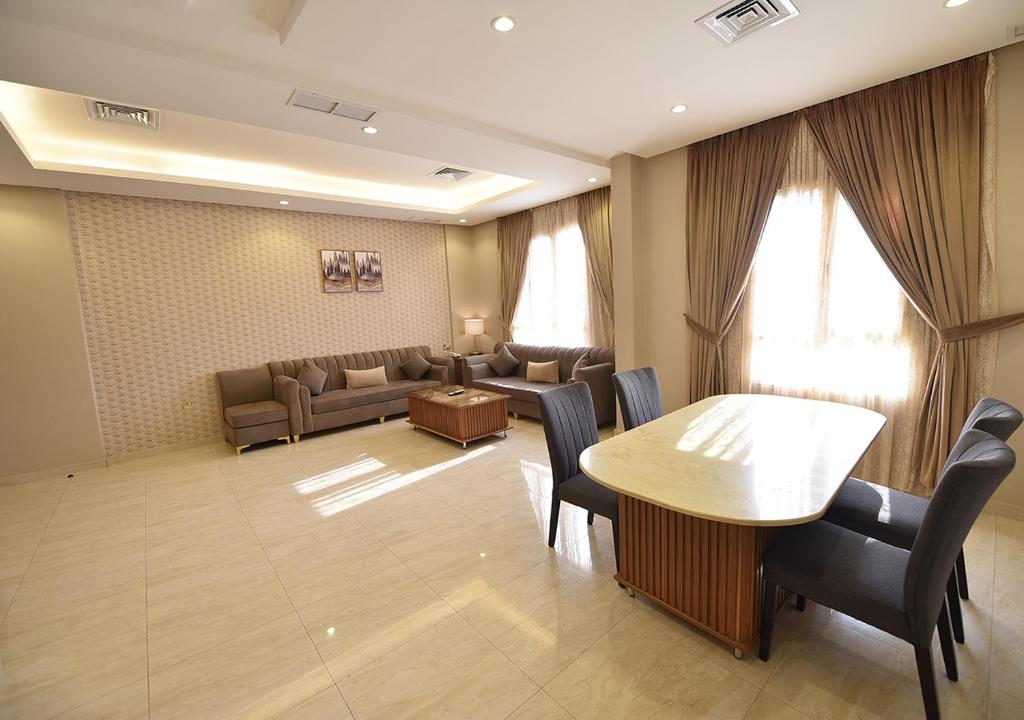 الدرة للشقق الفندقية في الكويت: غرفة معيشة مع طاولة وكراسي وأريكة
