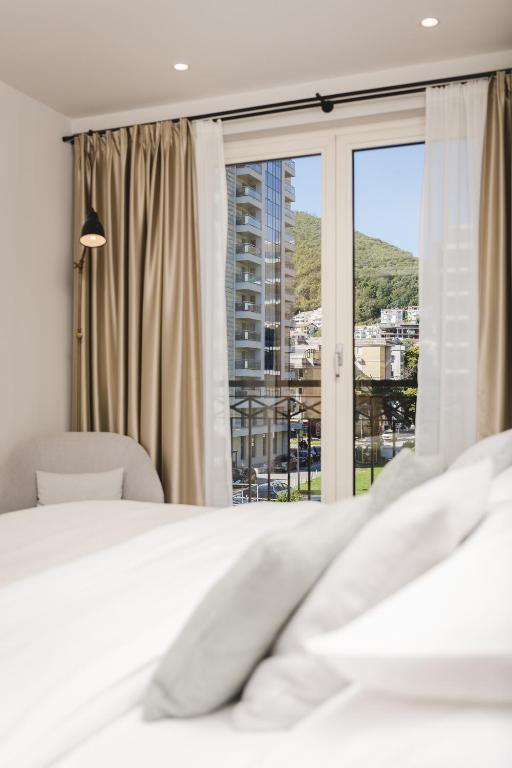 um quarto com uma cama e uma janela grande em Hotel Budva em Budva