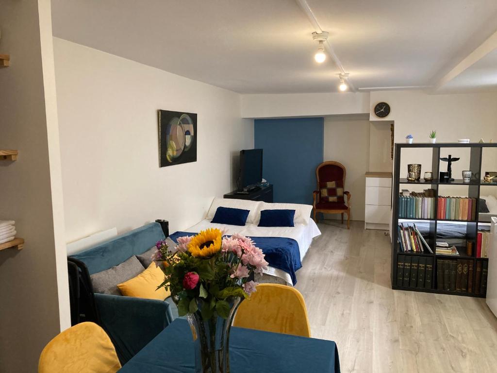 a bedroom with a bed and a table with a vase of flowers at Une chambre chez nous, à 12 minutes de Paris in Malakoff