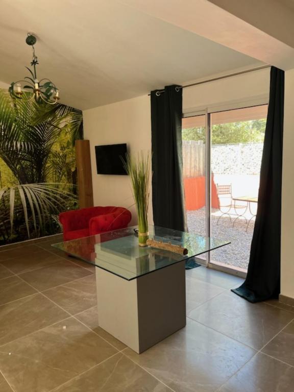- un salon avec une table en verre et un canapé rouge dans l'établissement Gîte - Les Salons du Bastier, à Ginasservis
