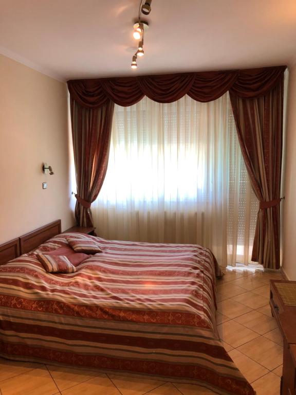 ein Bett in einem Schlafzimmer mit einem großen Fenster in der Unterkunft Hotel Ajka 1 in Ajka