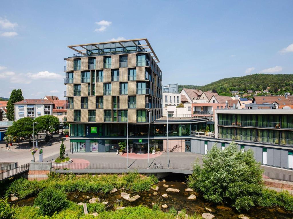 a tall building with a bridge in front of it at ibis Styles Nagold-Schwarzwald in Nagold