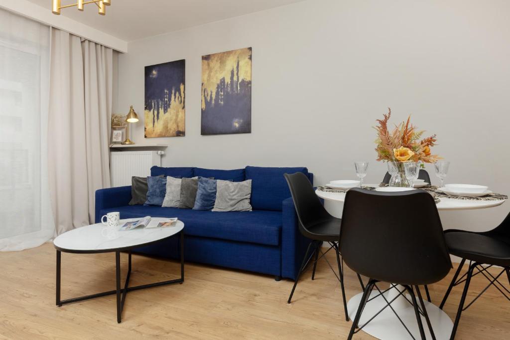 salon z niebieską kanapą i stołem w obiekcie Modern Apartment with Balcony Mokotów Business Centre by Renters w Warszawie