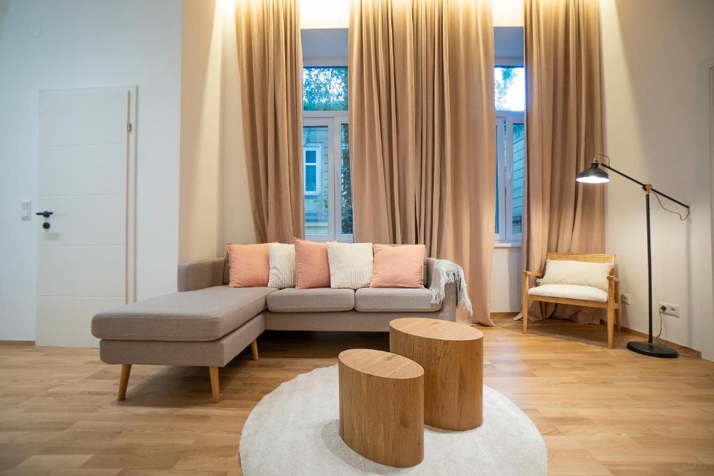 een woonkamer met een bank en twee houten krukken bij 2-rooms spacious apartment in a vibrant cozy area in Wenen