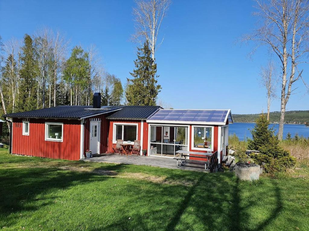 een rood huis met een zonnedak op een tuin bij Ytterfalle 169 in Härnösand
