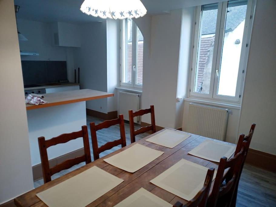 een eetkamer met een tafel en stoelen en een keuken bij Autun cœur de ville in Autun