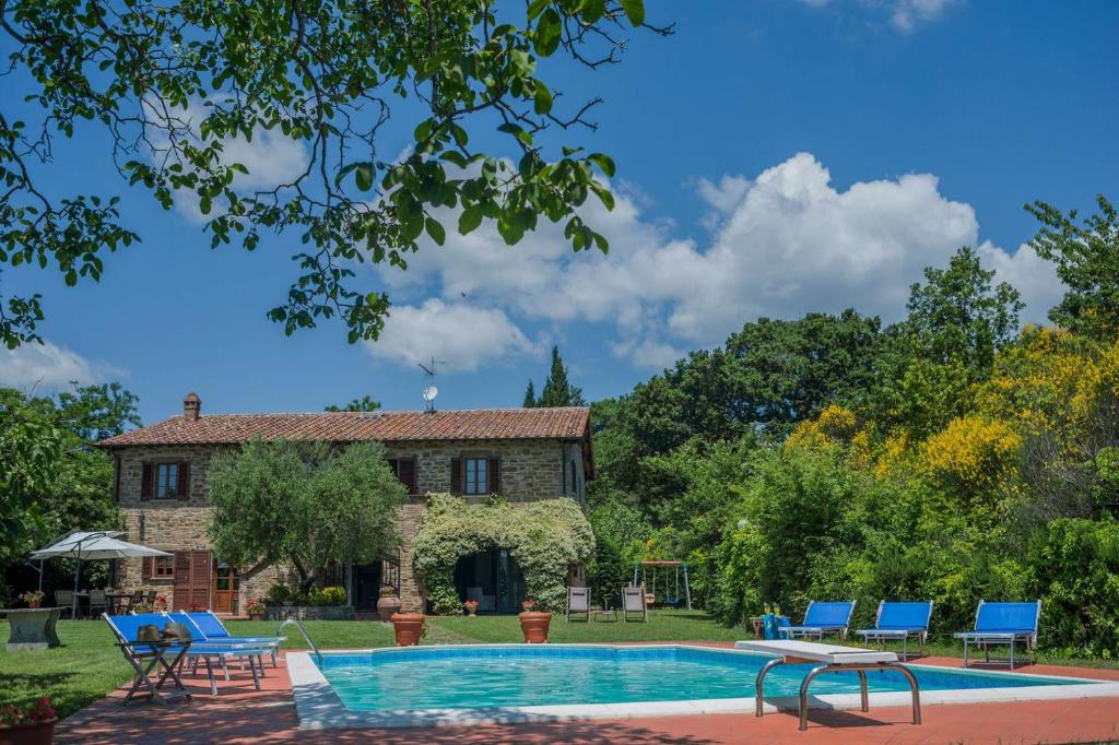 uma villa com uma piscina e uma casa em Villa Petroia 8 em Gubbio