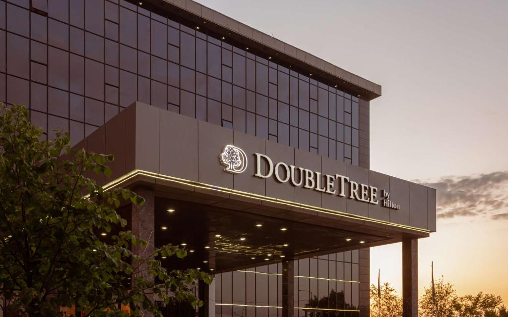 un edificio con l'insegna dell'albero di dolittle di DoubleTree by Hilton Shymkent a Shymkent