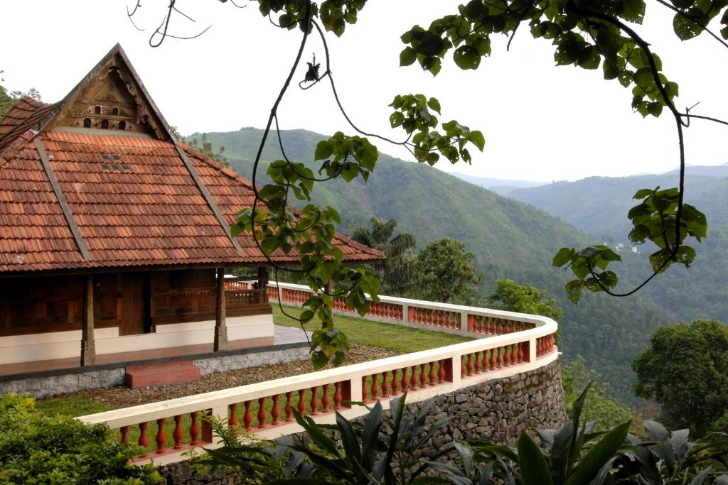 a building with a balcony and mountains in the background at Paradisa Nature Resort in Pīrmed