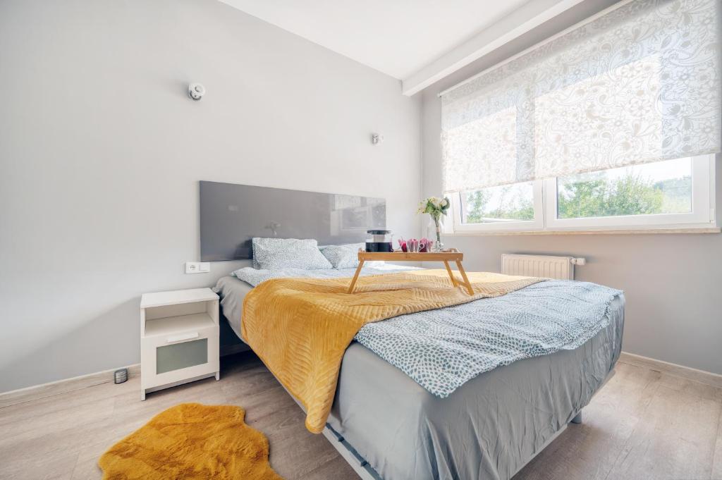 Un dormitorio con una cama con una mesa. en Orientarium Business Apartments with Parking by Rentujemy, en Łódź