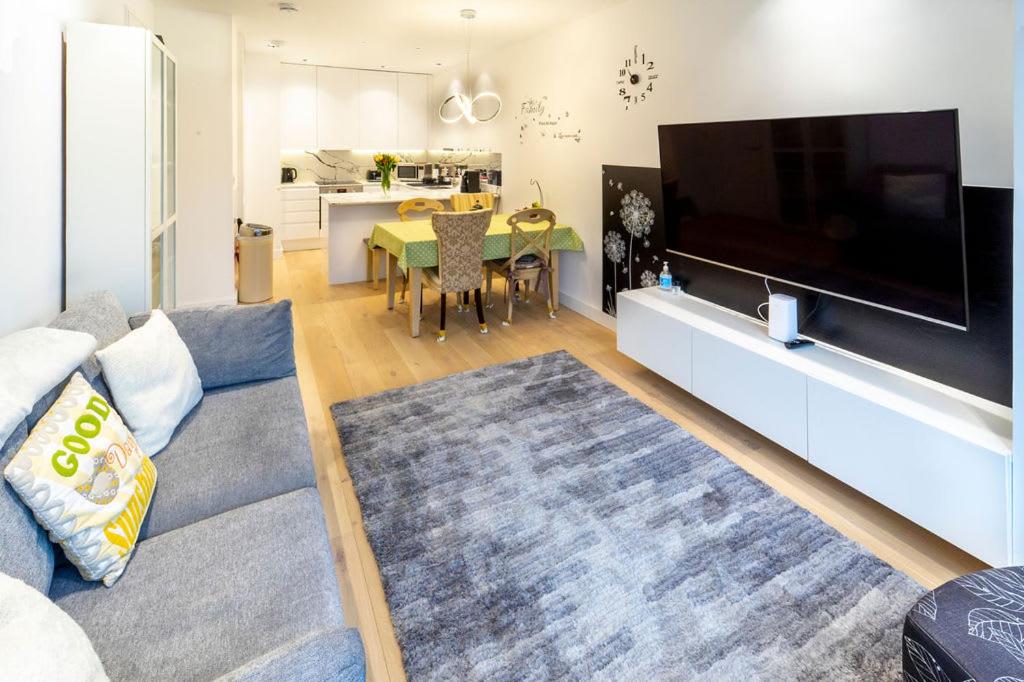 Modern and Bright Ealing Common Duplex في لندن: غرفة معيشة مع تلفزيون بشاشة مسطحة كبيرة