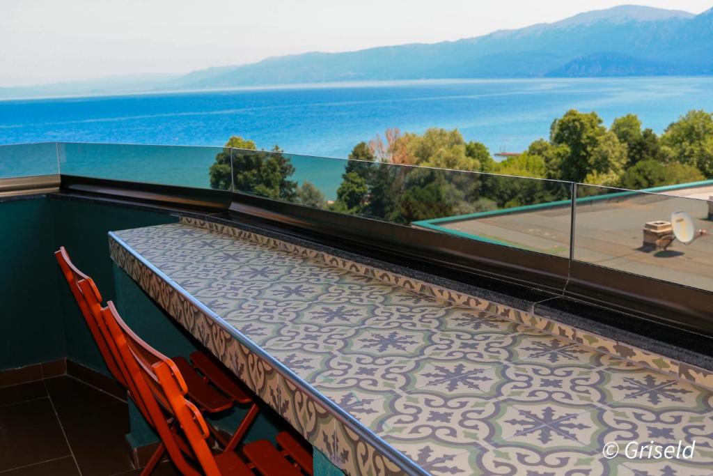 a balcony with a table and chairs and a view of the water at Drion Apartment with lake view in Pogradec
