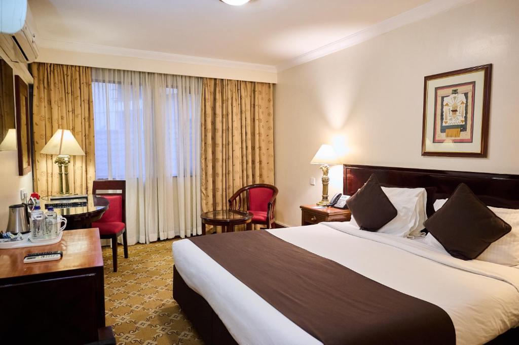 Postel nebo postele na pokoji v ubytování Jacaranda Hotel Nairobi