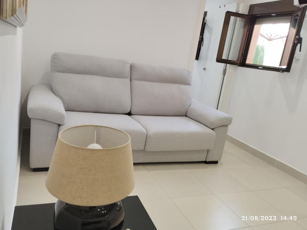een woonkamer met een bank en een tafel met een lamp bij Apartamento Agradable1 in Madrid