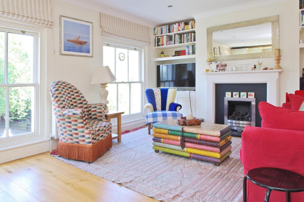 een woonkamer met kleurrijke stoelen en een open haard bij Notting Hill Light & Airy in Londen