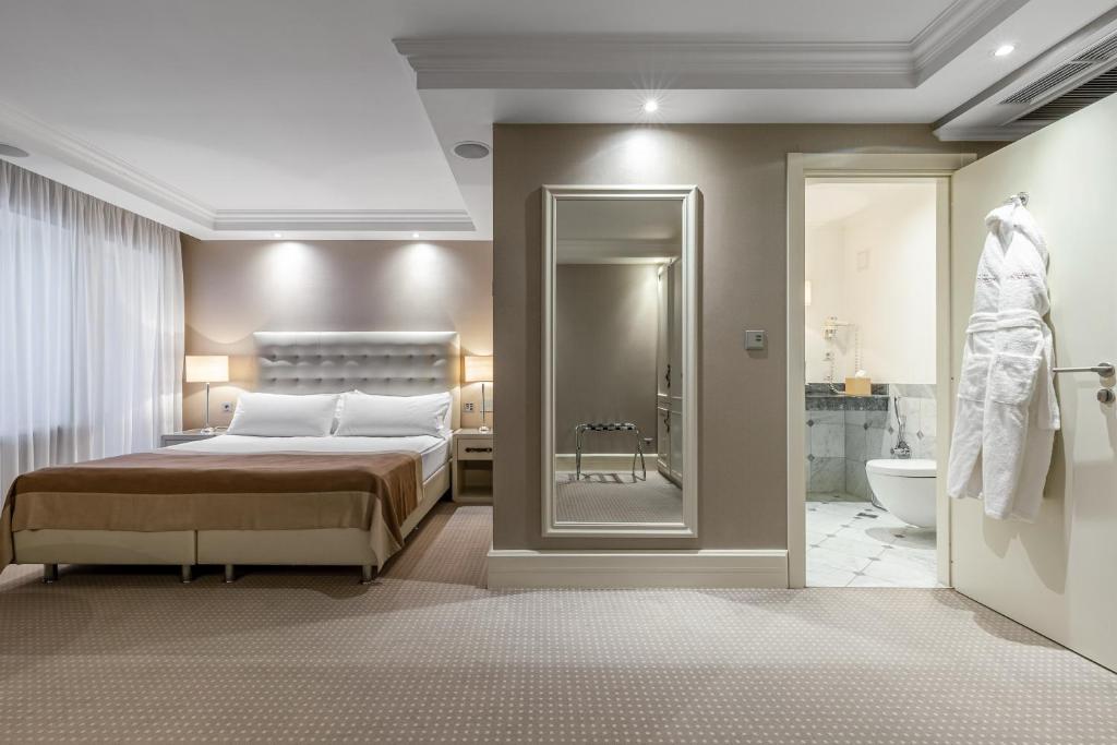 a bedroom with a large bed and a bathroom at Khreschatyk Hotel in Kyiv