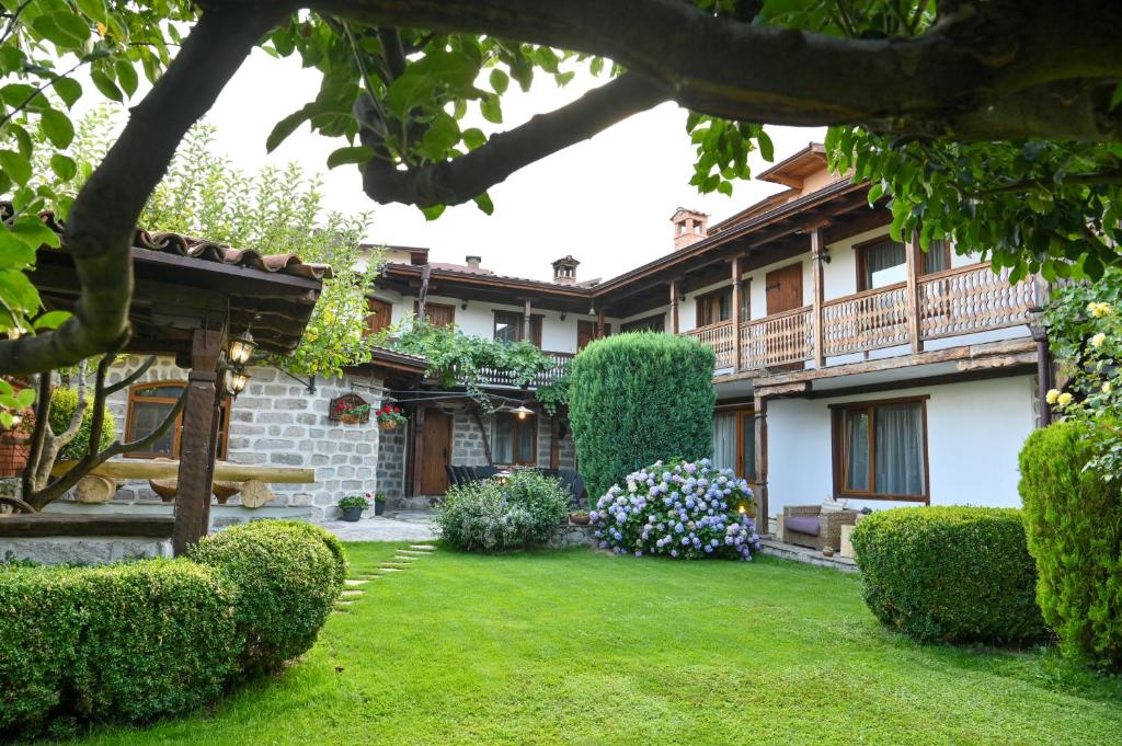 a garden in front of a house with bushes at Klecherova House in Bansko