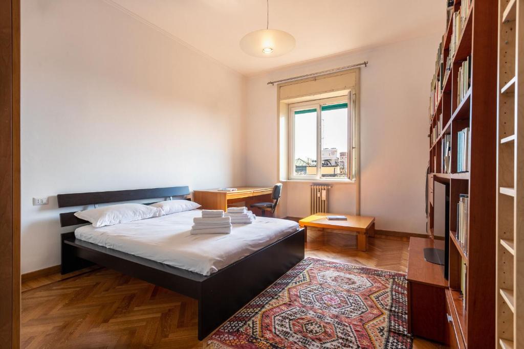 sypialnia z łóżkiem, biurkiem i oknem w obiekcie Garibaldi Two Bedrooms w Mediolanie