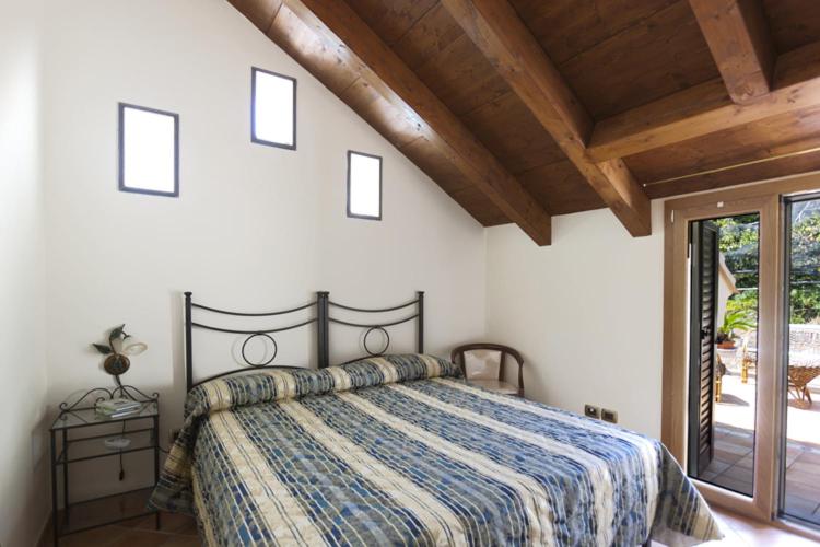 a bedroom with a bed with a blue comforter at La Lanterna in Cetara