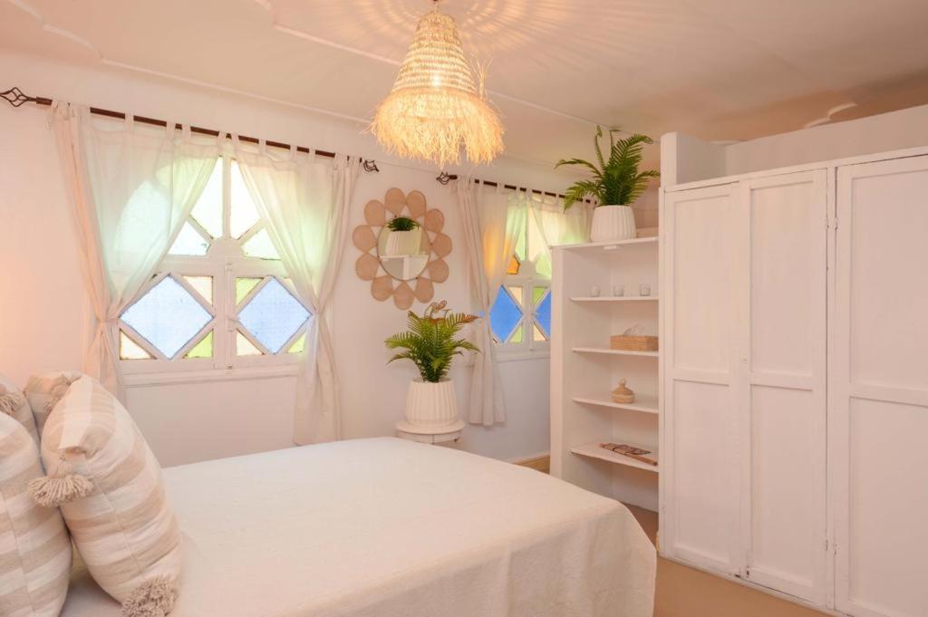 una camera con letto bianco e lampadario pendente di Rooftop centre ville jacuzzi a Marrakech
