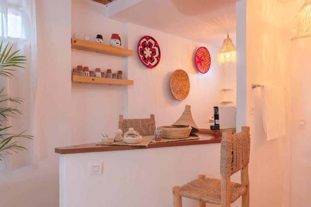 una cucina con bancone, sedie e piatti appesi al muro di Rooftop centre ville jacuzzi a Marrakech
