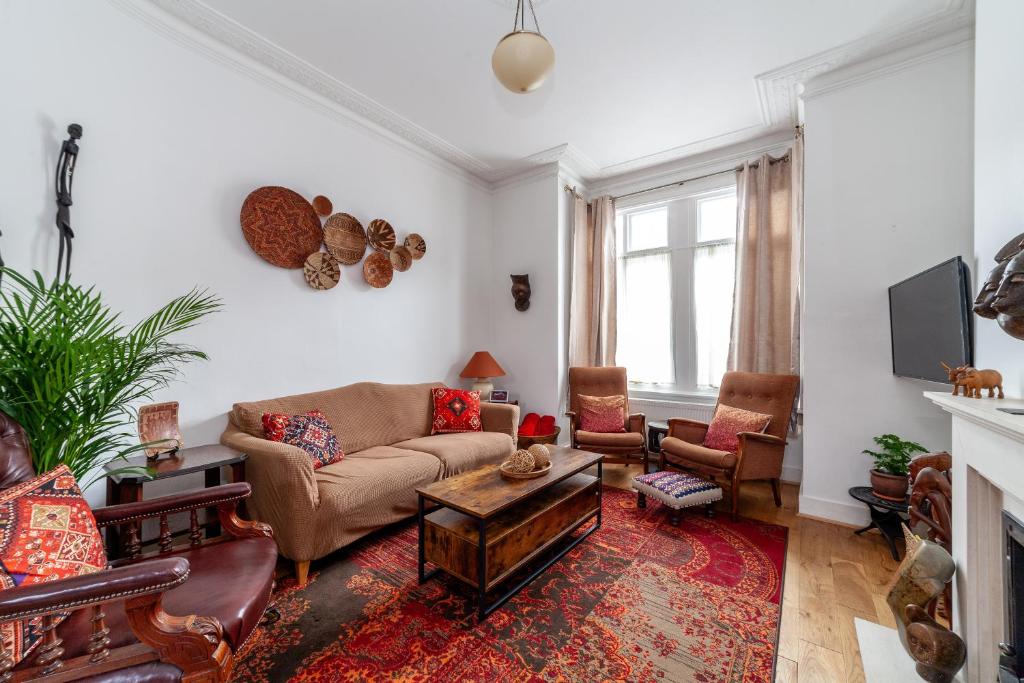 a living room with a couch and a fireplace at Charming Terraced 3BR House, 5 min Hither Green St in London