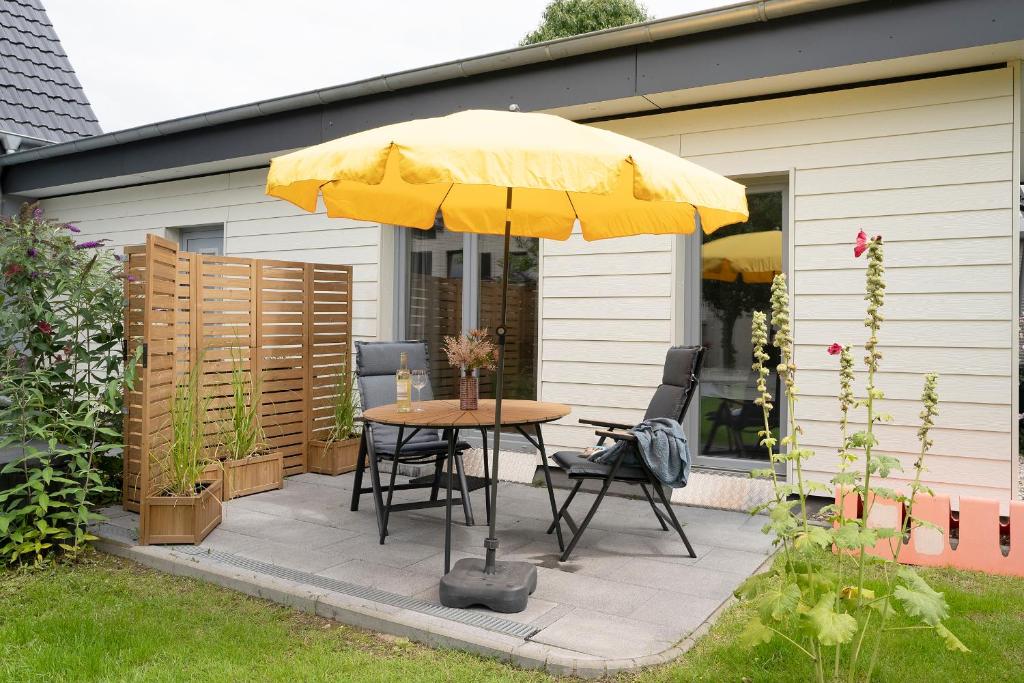 a table with a yellow umbrella on a patio at Haus Alouette in Dahme