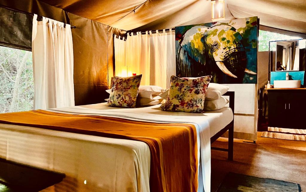 a bedroom with a bed with a painting of an elephant at Mahoora Wilpattu - by Eco Team in Wilpattu