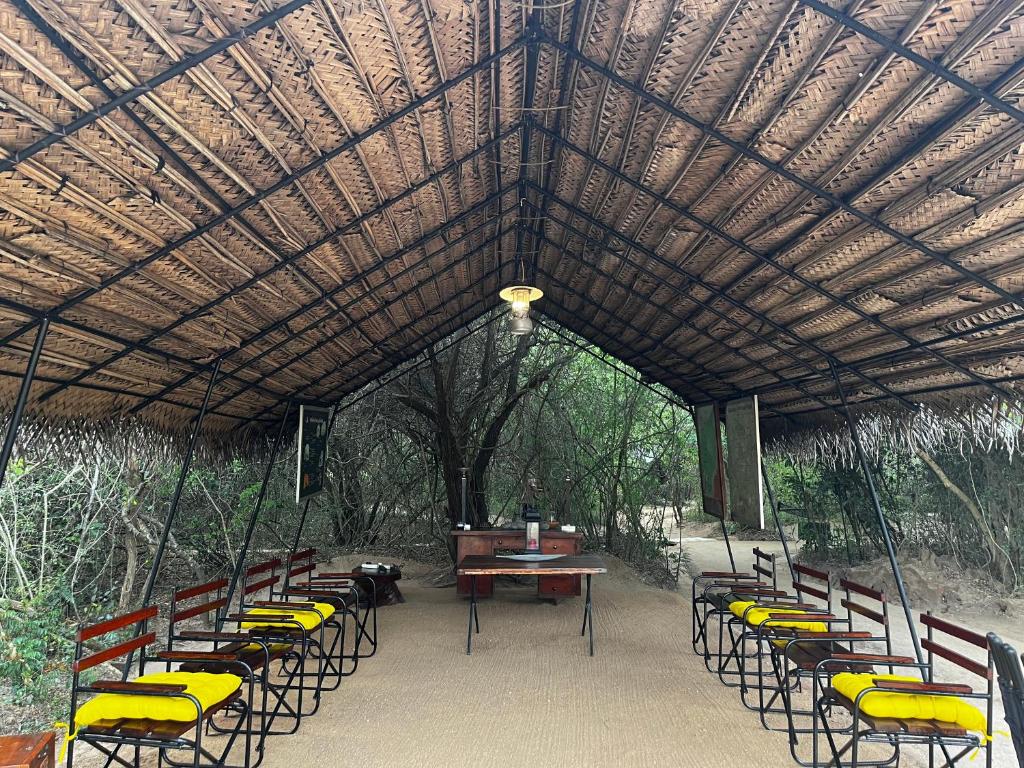 a pavilion with chairs and a table and a piano at Mahoora Wilpattu - by Eco Team in Wilpattu