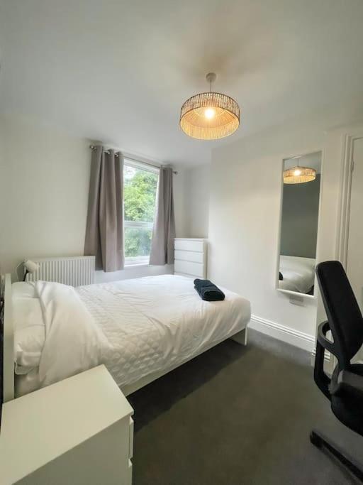 a bedroom with a white bed and a window at Newly refurbished 3 bed house in Hull