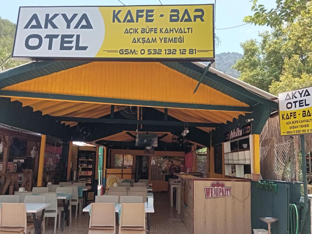 a restaurant with tables and chairs and a sign at Akya Adrasan Pansiyon in Adrasan