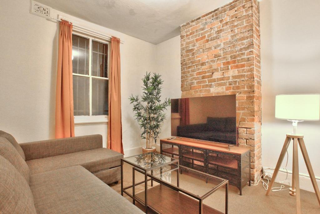 a living room with a couch and a brick fireplace at 3 Bedrooms - Darling Harbour - Glebe St 2 E-Bikes Included in Sydney