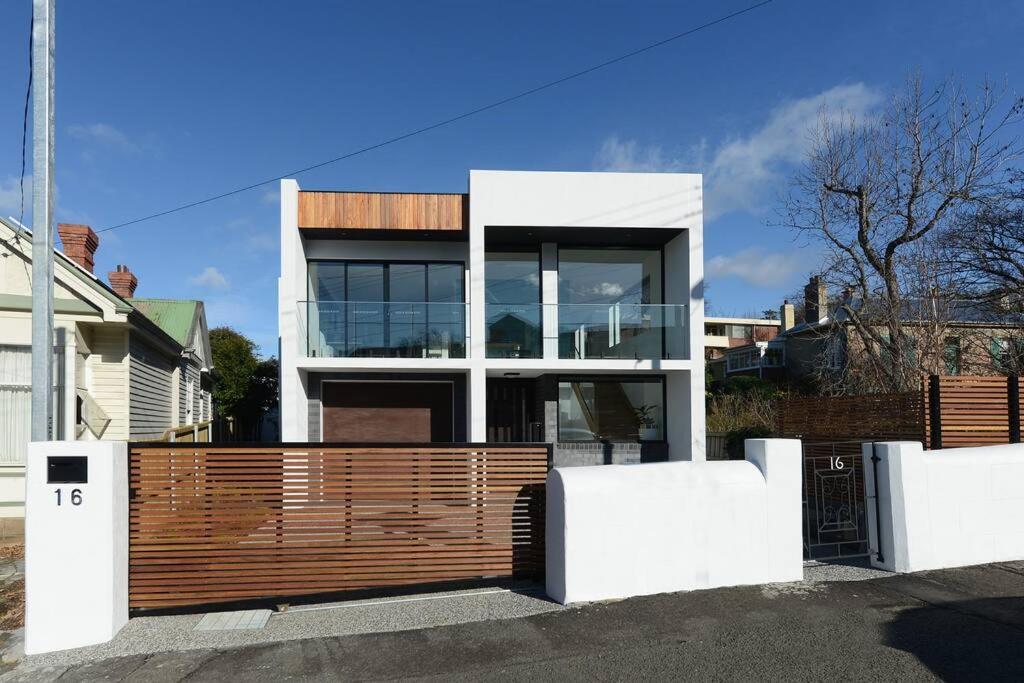 a house with a wooden fence in front of it at Modern Sandy Bay Apt - Close to Salamanca & CBD in Sandy Bay